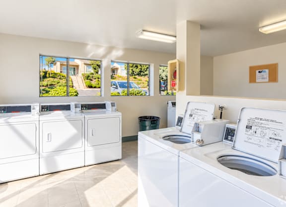 A laundromat with washers and dryers is shown.
