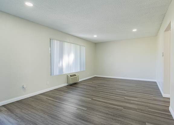 A room with a window and a heater on the floor.