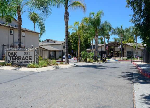 a street with houses on each side and a sign that reads oak 51 terrace at Oak Terrace Senior Apts, Hemet California