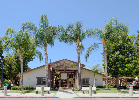 a building with palm trees in front of it at Oak Terrace Senior Apts, Hemet, CA 92543   