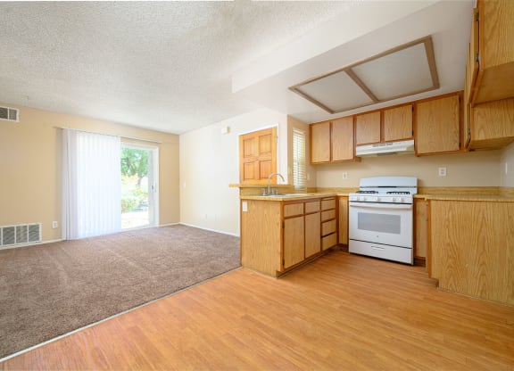 a kitchen and living room with a sliding glass door leading to a patio at Oak Terrace Senior Apts, Hemet California