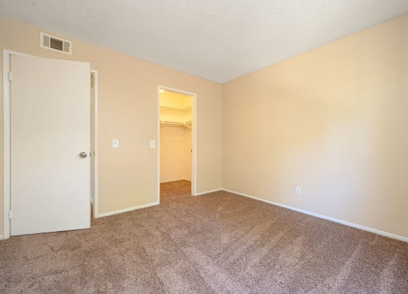 a bedroom with a carpeted floor and an open door at Oak Terrace Senior Apts, Hemet California