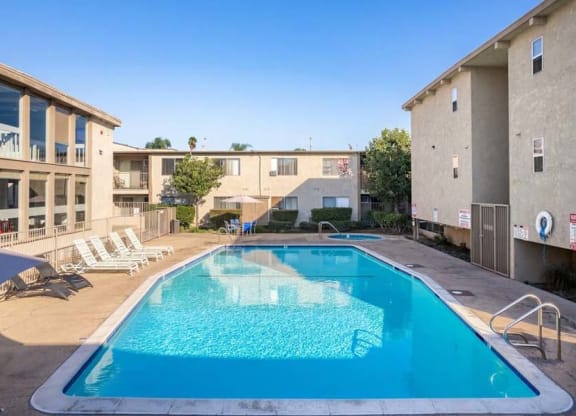 a swimming pool with chaise lounge chairs and a building in the background at Mountainview Venture, California