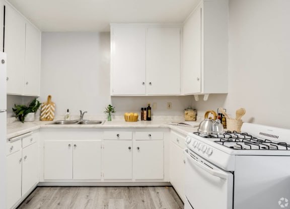 a white kitchen with white appliances and white cabinets at University Park, Azusa, CA