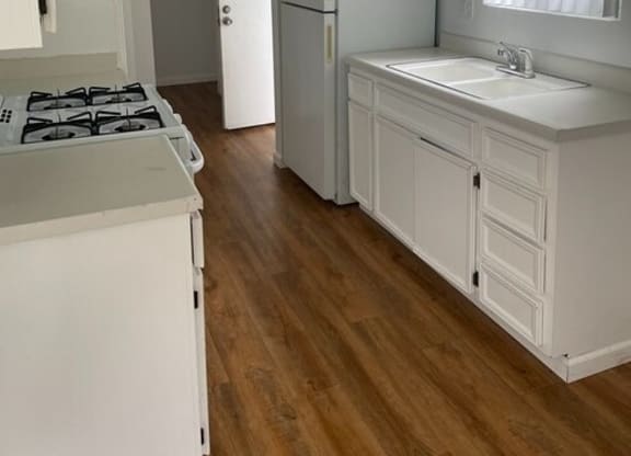 a kitchen with a stove top oven next to a sink at Fiesta Apts, Lompoc, CA 93436