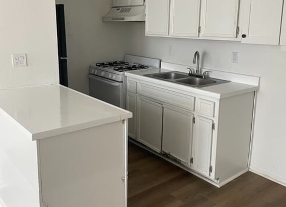 a kitchen with a stove top oven next to a sink at Fiesta Apts, Lompoc, CA