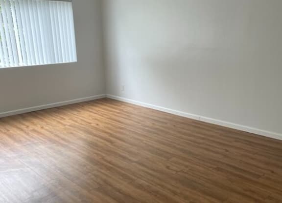 a bedroom with hardwood floors and a window at Fiesta Apts, Lompoc, CA