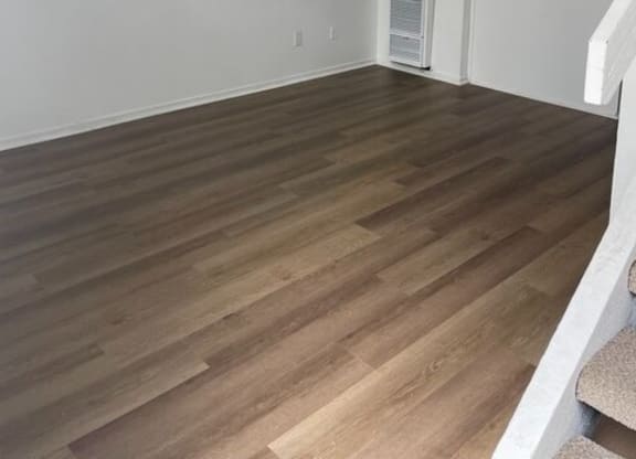 an empty living room with a staircase in the background at Fiesta Apts, Lompoc California