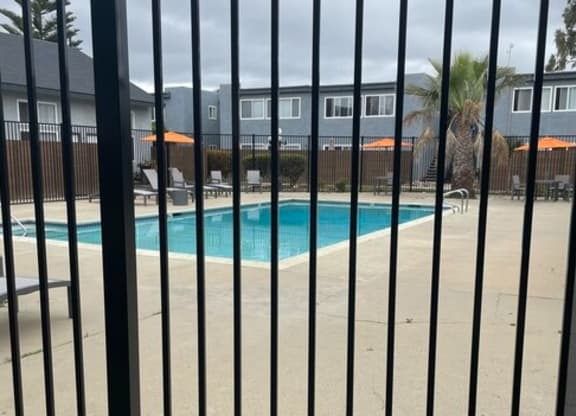 a swimming pool is seen through a fence at Fiesta Apts, California