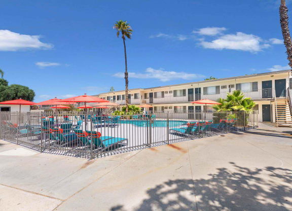 our apartments have a pool and patio with chairs and umbrellas at Sunnymead Apts Apartments, Moreno Valley, CA