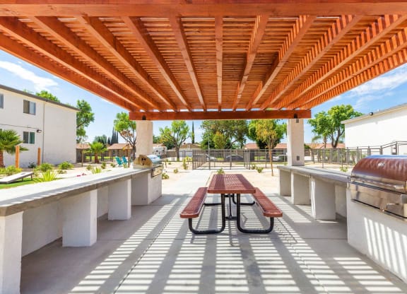 a patio with a picnic table and a grill at Sunnymead Apts Apartments, Moreno Valley, 92553