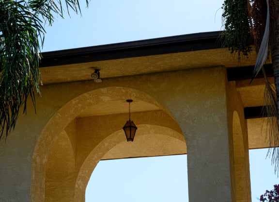 an archway with a light hanging from it with a blue sky in the background at Park Columbia Apts, Hemet, CA 92544