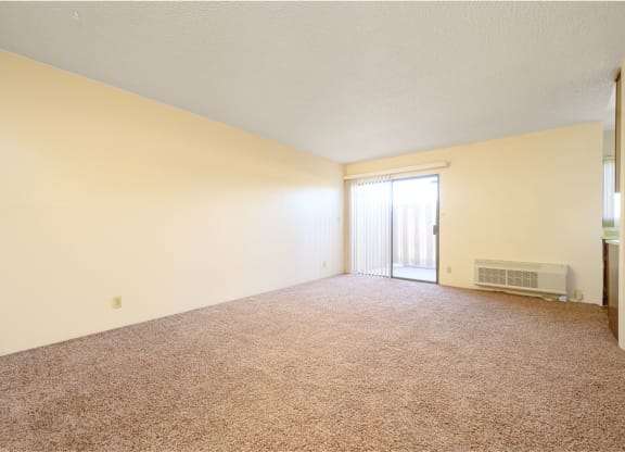 an empty living room with a door leading to a balcony at Park Columbia Apts, Hemet California