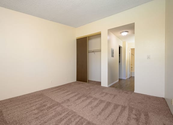 a bedroom with a carpeted floor and white walls at Park Columbia Apts, Hemet