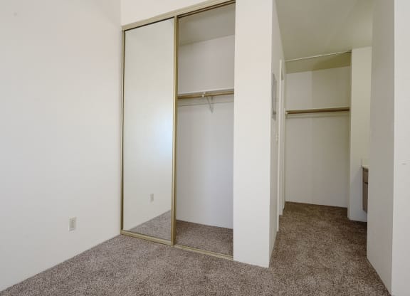 a bedroom with white walls and a carpeted floor at Park Columbia Apts, California