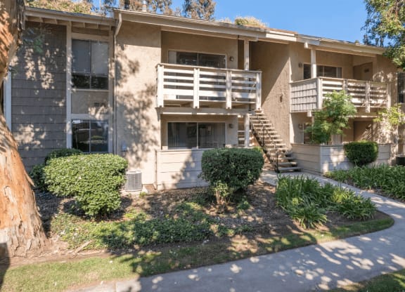 an apartment building with a sidewalk in front of it  at Alosta Place, Azusa, CA
