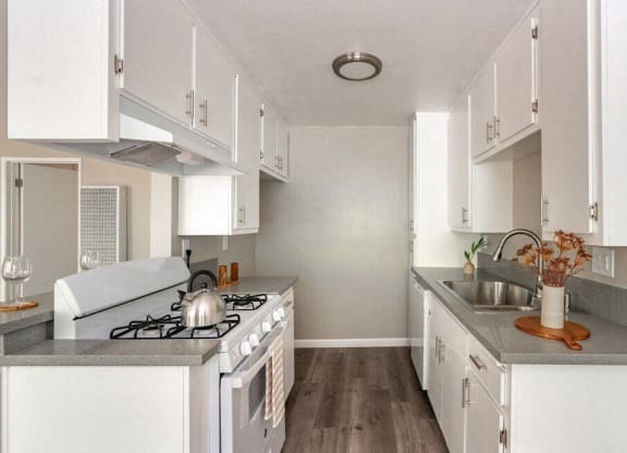 a white kitchen with a stove and a sink at North View Terrace, Montebello, CA 90640