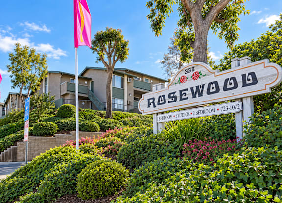 A sign for Rosewood in front of a building.