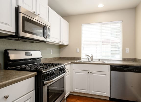 a kitchen with white cabinets and stainless steel appliances at Sagewood Gardens Senior Apartments, Hacienda Heights, CA 91745
