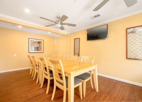 a dining room with a table and chairs and a flat screen tv at Sagewood Gardens Senior Apartments, Hacienda Heights, CA