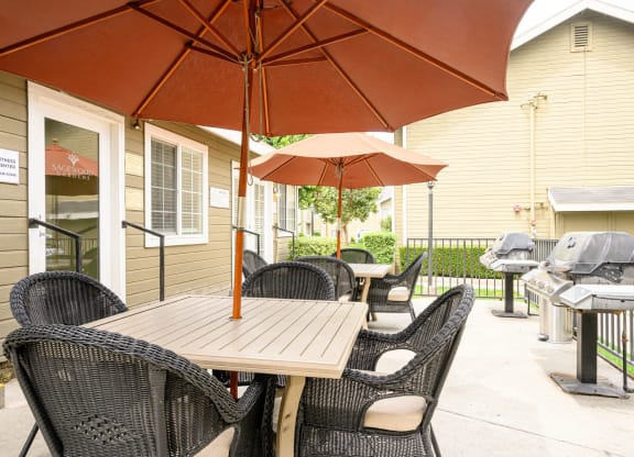 a patio with a table and chairs and an umbrella at Sagewood Gardens Senior Apartments, Hacienda Heights, CA 91745