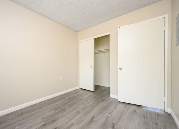 a bedroom with hardwood floors and beige walls at Sagewood Gardens Senior Apartments, Hacienda Heights, 91745