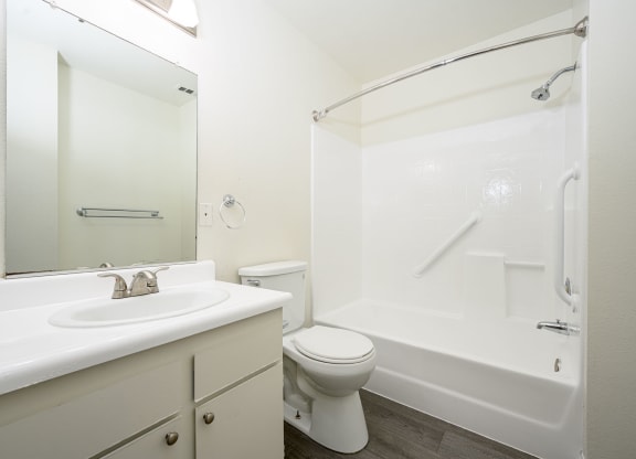 a bathroom with a bathtub toilet sink and mirror at Sagewood Gardens Senior Apartments, Hacienda Heights, CA