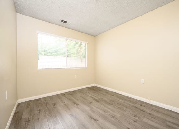a bedroom with hardwood floors and beige walls at Sagewood Gardens Senior Apartments, Hacienda Heights, 91745
