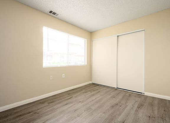 a bedroom with two closets and a window at Sagewood Gardens Senior Apartments, California