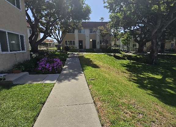 A sunny day at a residential area with a sidewalk and green grass.