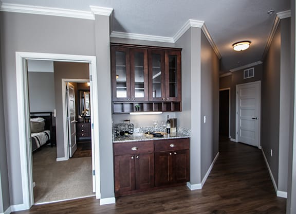 a kitchen with dark wood cabinets and granite countertops  at Victoria Park and V2 Apartments, St. Paul, Minnesota