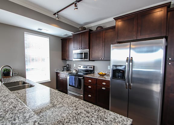 a kitchen with granite countertops and stainless steel appliances  at Victoria Park and V2 Apartments, St. Paul, MN, 55102