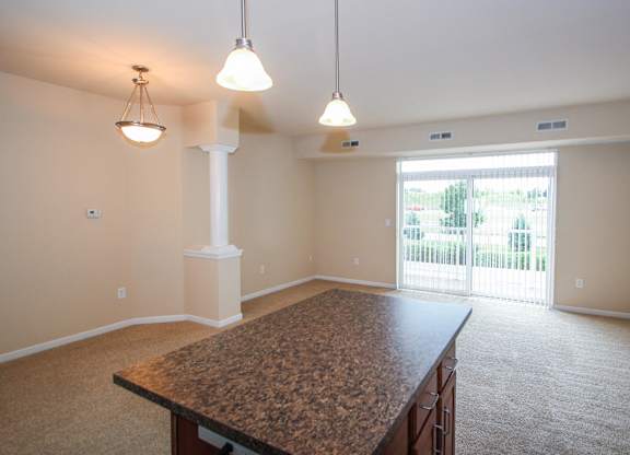 a kitchen and living room with a large sliding glass door