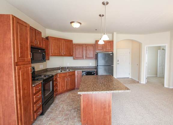 a kitchen with wood cabinets and black appliances