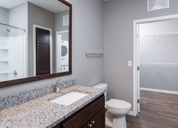 a bathroom with a toilet sink and mirror  at Victoria Park and V2 Apartments, Minnesota