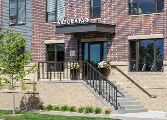 the entrance of a brick building with a sign that says victoria park  at Victoria Park and V2 Apartments, Minnesota, 55102