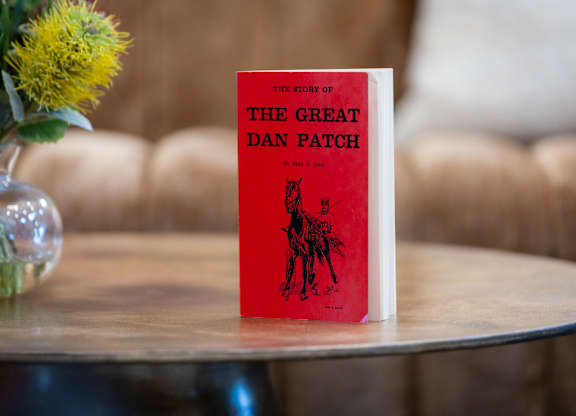 A red book titled The Story of the Great Dan Patch sits on a table.
