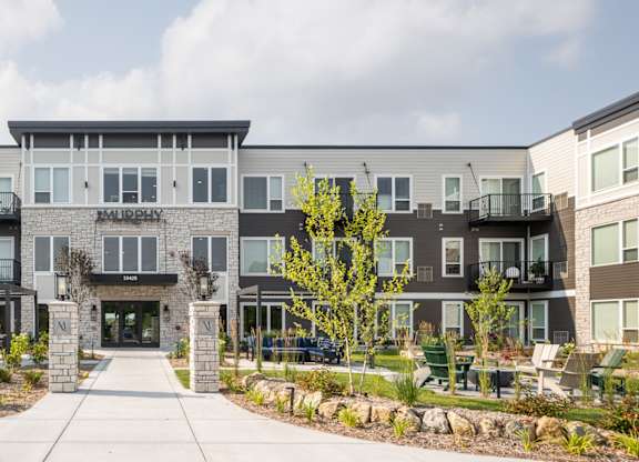 A modern building with a central entrance and a landscaped courtyard.