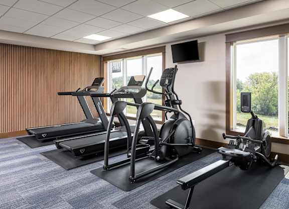 A gym with treadmills and elliptical machines.