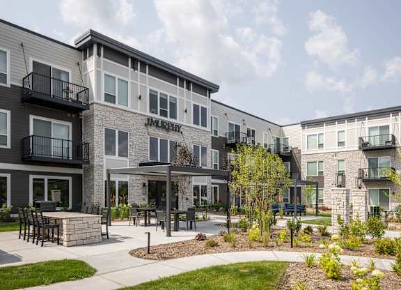 Apartment complex named Jamie with a patio and landscaping.