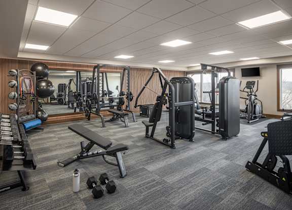A well-equipped gym with a variety of exercise machines and weights.
