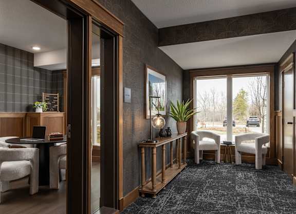 A modern living room with a dining area and a view of the outdoors.