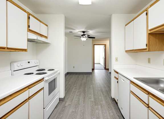 A kitchen with white cabinets and a wood trim.