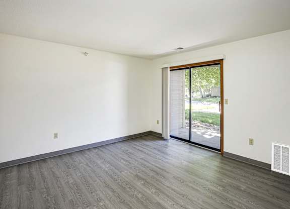 A room with a sliding glass door leading to a backyard.