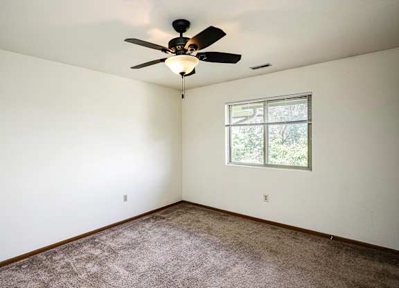 A room with a ceiling fan and a window.