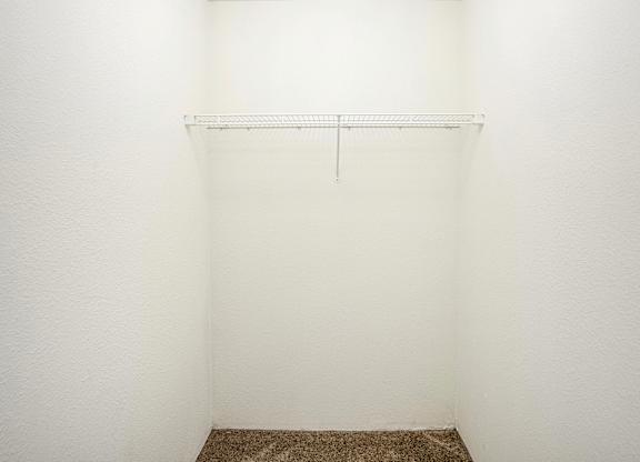 A white wall with a metal shelf on it.