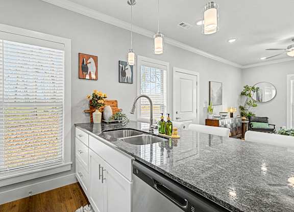 A kitchen with a granite countertop and white cabinets.