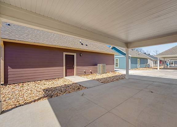 A covered outdoor area with a concrete floor and a roof.
