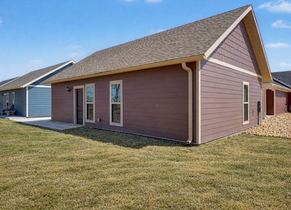 A small house with a brown roof and a brown siding.