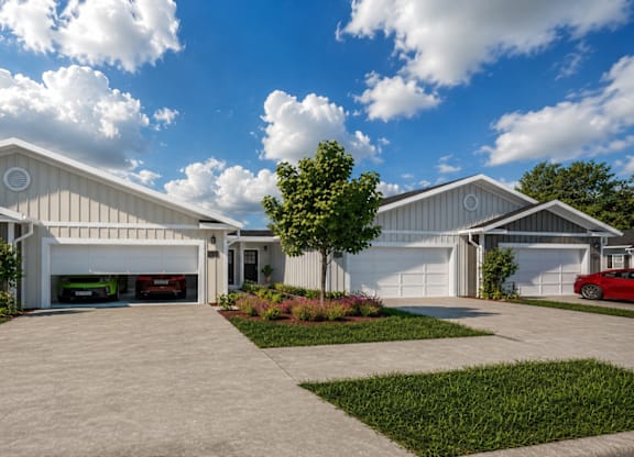 A modern house with a red car parked in the driveway.